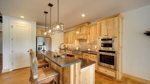A modern kitchen with wooden cabinets, a central island, stainless steel appliances, and pendant lighting. - Horseshoe Bay Resort Home ~ 6 Mi to Lake Lbj! (Horseshoe Bay)