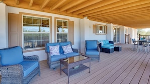 A covered outdoor seating area with wicker furniture and large windows. - 11 Mi to Saguaro Nat'l Park! Family Home w/ Deck (Tucson)