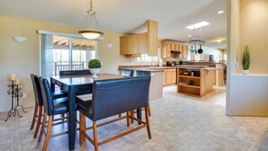 A spacious kitchen with a central island, wooden cabinets, and a dining area with a table and chairs. - 11 Mi to Saguaro Nat'l Park! Family Home w/ Deck (Tucson)