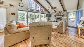 A spacious living room with a high ceiling, wooden beams, and large windows offering a view of the outdoors. - Rustic Alto Retreat - Near Hiking, Skiing & More! (Alto)