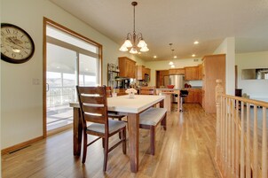 Una cocina amplia con armarios de madera, una mesa de comedor con sillas y un ventanal grande.