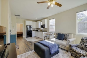 A modern apartment with a kitchenette, a dining area, and a living room with a sofa and ottoman. - Desirable Reno Apartment: 15 Mi to Ski Slopes! (Reno)