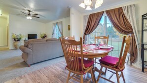 A dining area with a wooden table and chairs, a ceiling fan, and a sofa in the background. - Spacious De Tour Village Home Near Lake Huron! (De Tour Village)