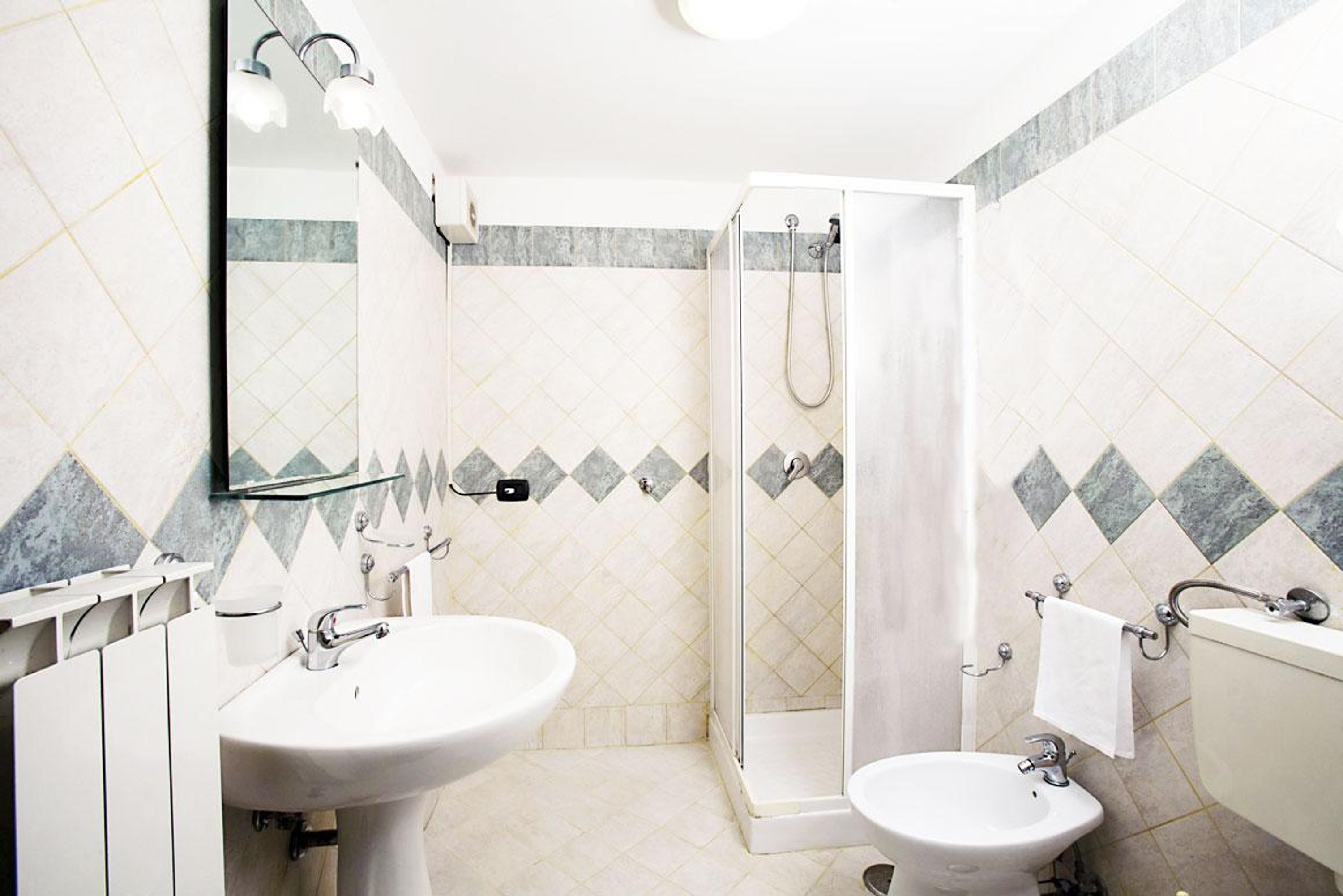 A bathroom with a shower, two sinks, and a mirror.