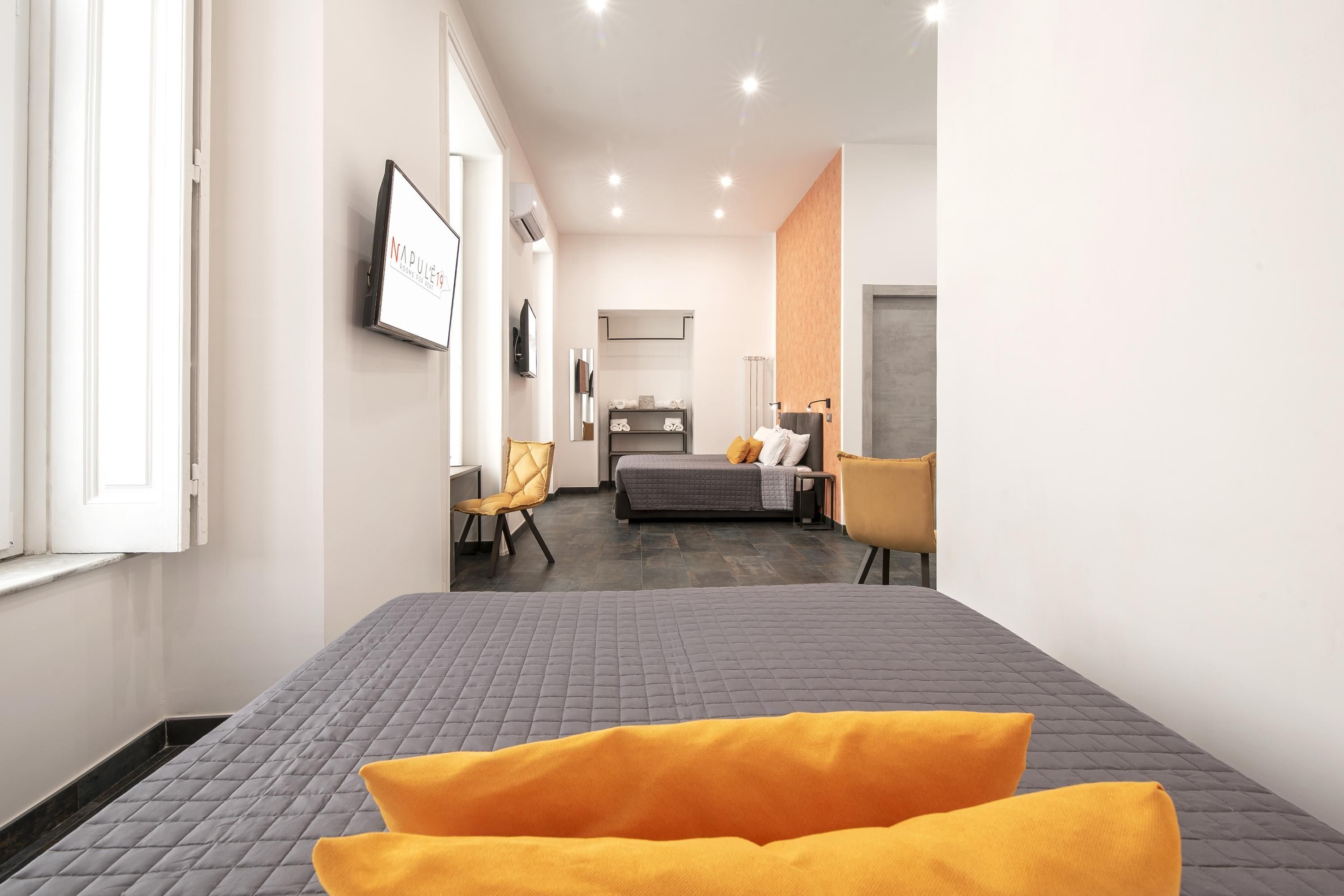 Una habitación de hotel moderna con una cama grande, un escritorio, una silla y un televisor.