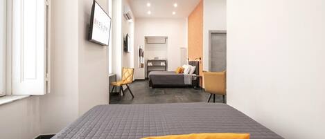 Una habitación de hotel moderna con una cama grande, un escritorio, una silla y un televisor.