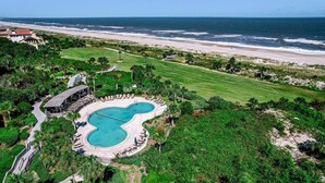 A resort with a pool, beach, and ocean view.