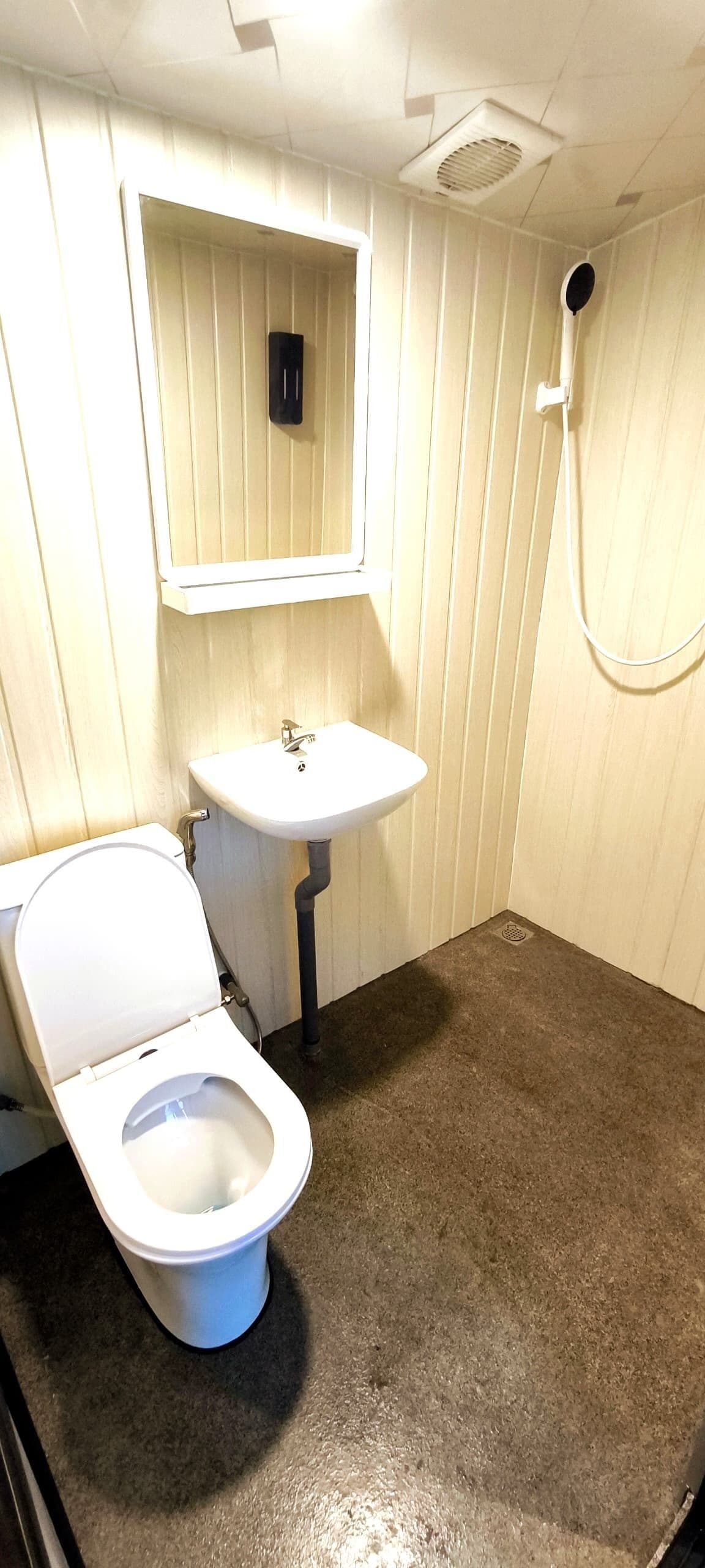Ein kleines Badezimmer mit Toilette, Waschbecken und Dusche.