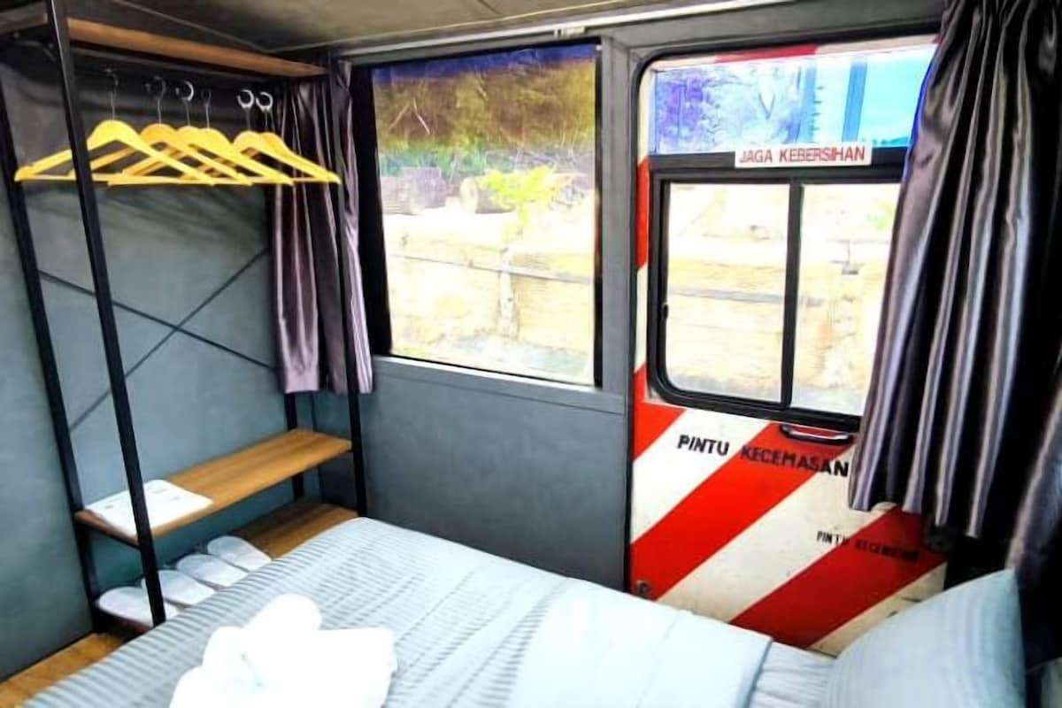Ein Zugabteil mit einem Bett, einer Ablage und einem Fenster.