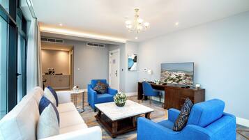 A modern living room with a sofa, armchairs, a coffee table, and a TV.