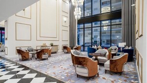 A spacious lobby with a checkered floor, modern furniture, and large windows offering a view of the city. - Sherao Hotel Doha - Next to National Museum of Qatar & Metro (Doha)