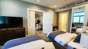 Una habitación de hotel con dos camas, televisión, escritorio y baño.