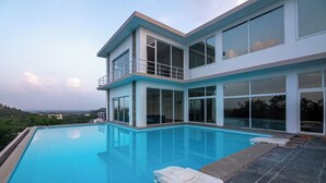 A modern two-story house with a large swimming pool.
