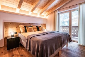 Relax in this serene bedroom with a large bed, wooden headboard, and a cozy reading nook.