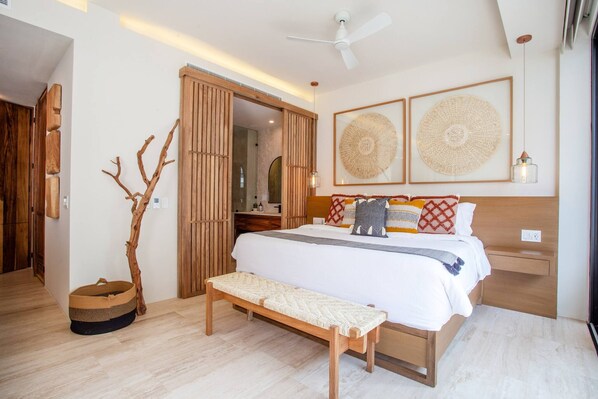 A modern bedroom with a bed, bench, and decorative wall art.