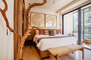 Un dormitorio con una cama grande, una estructura de tronco de árbol de madera y vistas al exterior a través de un ventanal.
