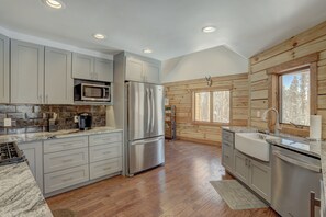 A modern kitchen with grey cabinets, stainless steel appliances, and a wooden interior. - Big Blue Trace (Breckenridge)