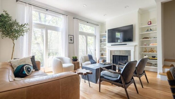 Una sala de estar moderna con chimenea, televisor y estantería.