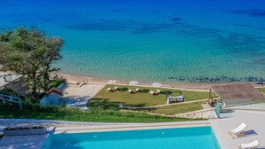 Une piscine avec des chaises longues et vue sur la mer.