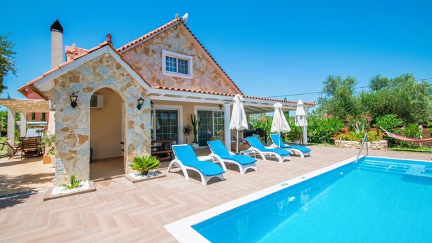A stone house with a swimming pool, blue lounge chairs, and a garden. - Zante Sun I - Getaway Villa! (Zakynthos)