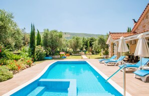 Relax by the pool surrounded by lush greenery and vibrant flowers.
