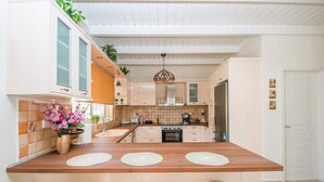 A modern kitchen with a central island, white cabinets, and a wooden countertop. - Zante Sun I - Getaway Villa! (Zakynthos)