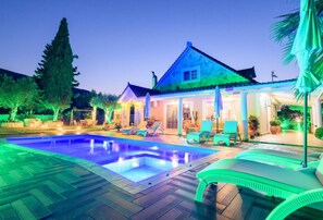 Relax by the pool surrounded by lush greenery and comfortable lounge chairs.