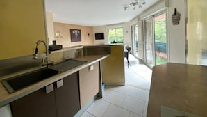 Een moderne keuken met een groot schiereiland, een spoelbak en een raam met uitzicht op de omgeving.