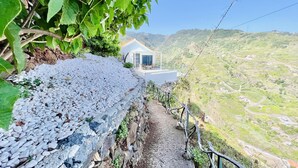 A pathway leading to a house with a view of a valley. - Mar a Vista by Your Madeira Rentals (Ponta do Sol)