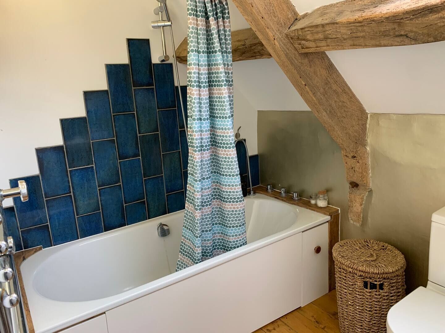 A bathroom with a bathtub, a shower curtain, a sink, and a toilet.