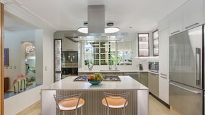 A modern kitchen with a central island, stainless steel appliances, and a view of the outdoors. - 5BR Villa with Pool&Beach in Punta Cana (Punta Cana)