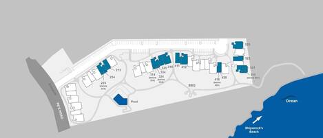 A coastal hotel layout with numbered rooms, a pool, and a beach.