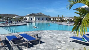 Ein Poolbereich mit Liegestühlen und einem Gebäude im Hintergrund.