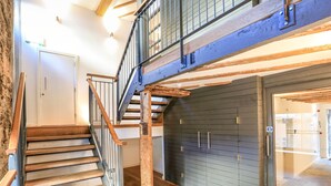 A wooden staircase with a metal railing leading to a second floor. - 4 The Pottery (Dartmouth)