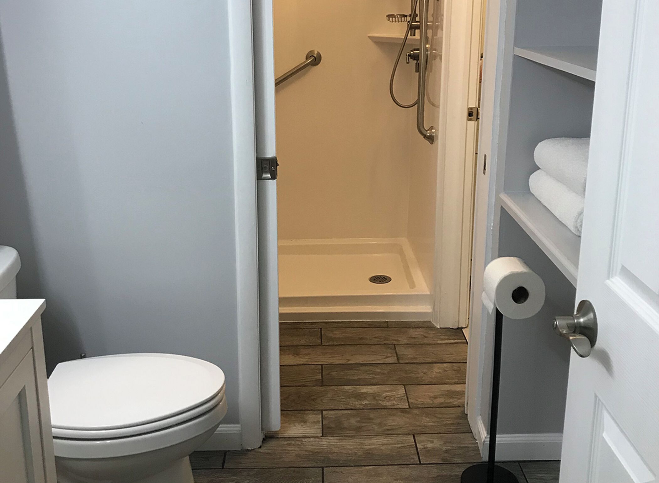 Une salle de bain équipée de toilettes, d’une douche et d’un porte-rouleau de papier toilette.