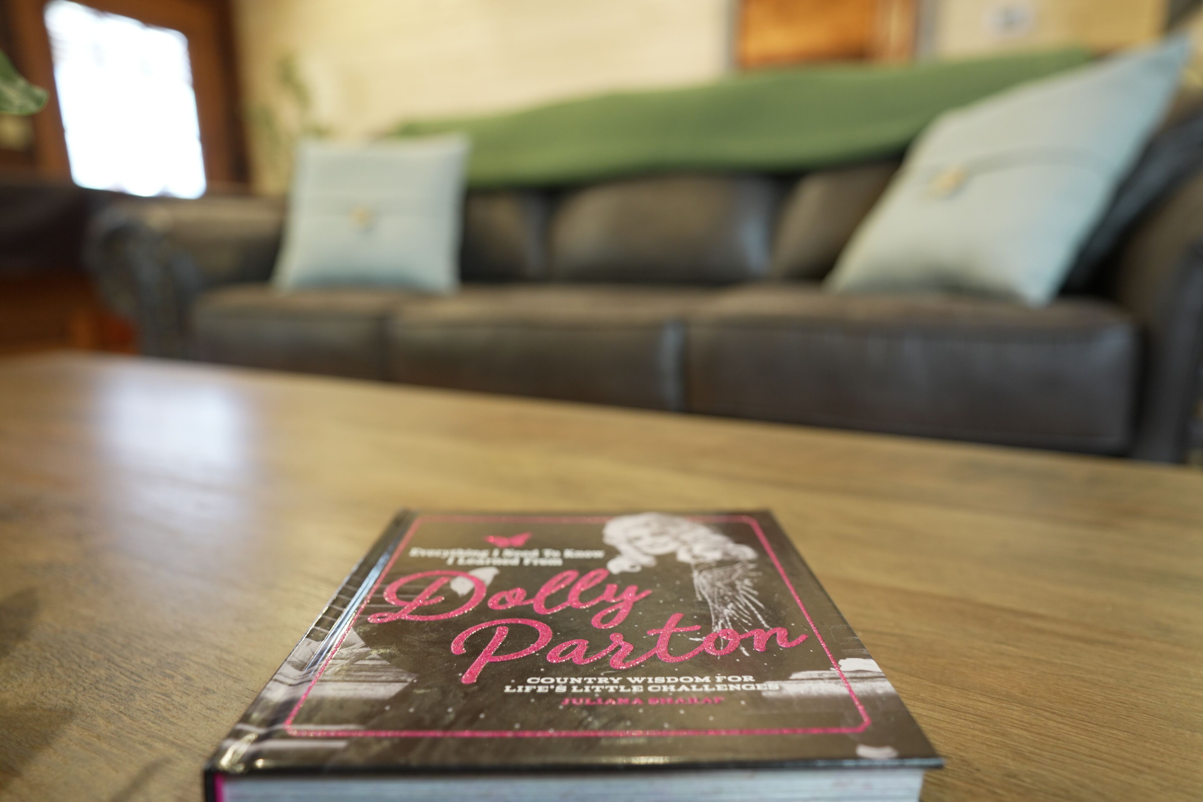 A book titled 'Dolly Parton' on a wooden table.