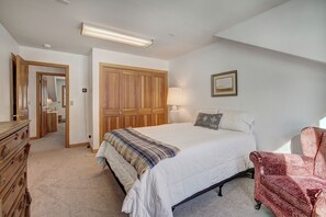 Quarto com cama, cômoda, cadeira e guarda-roupa.