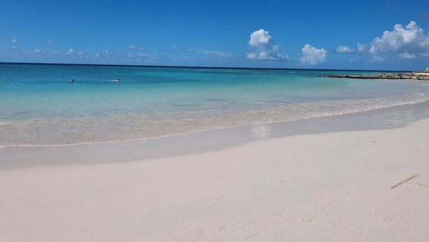 A beach with clear turquoise water and a white sandy shore.