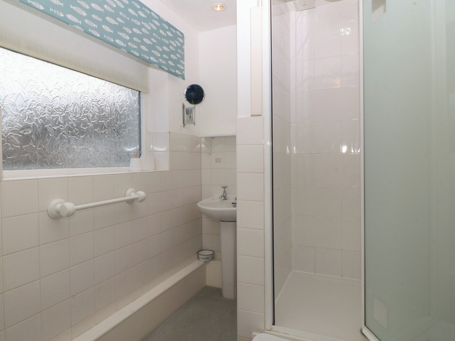 A bathroom with a bathtub, a sink, and a glass shower enclosure.