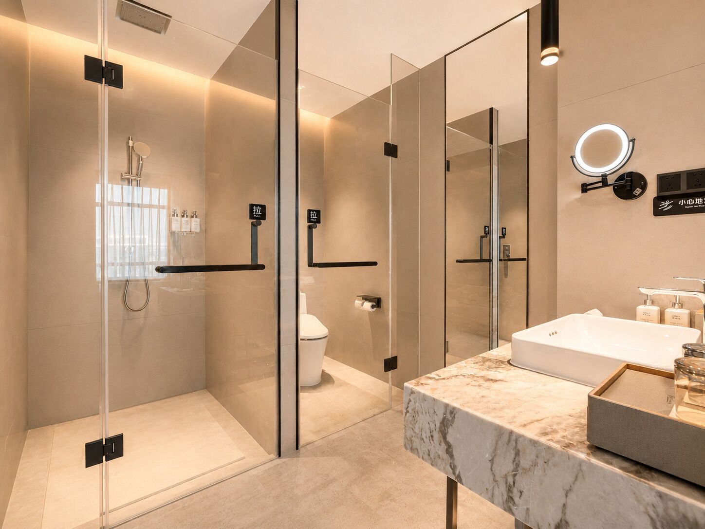 Ein modernes Badezimmer mit einer Glaskabine zur Dusche, Toilette und einem Marmor-Waschtisch mit Waschbecken und Spiegel.