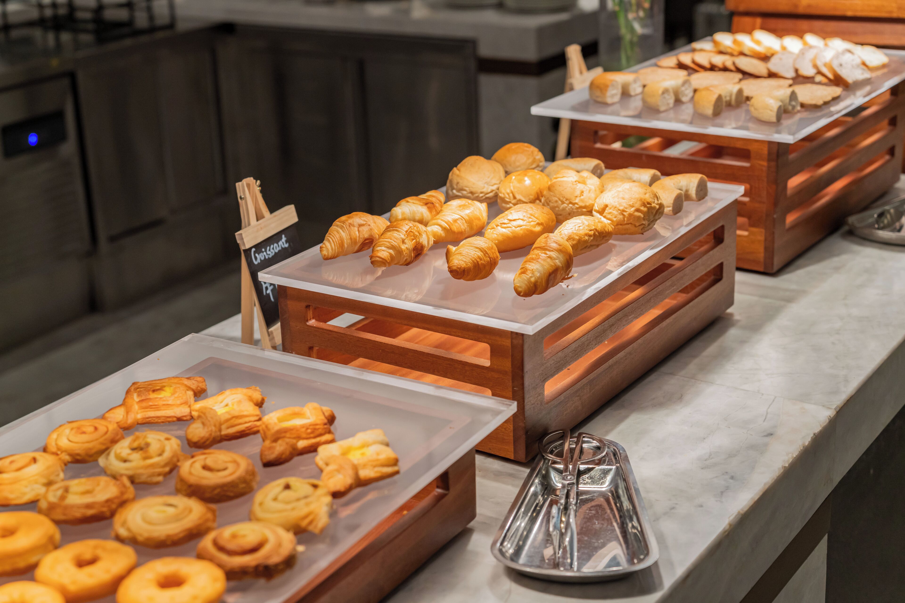 A bakery display with various pastries and bread.