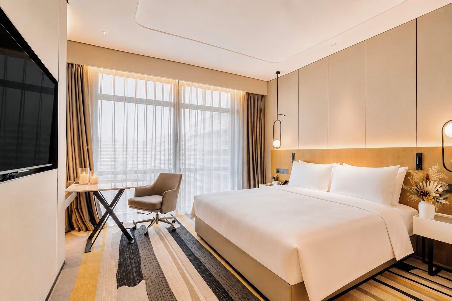 A hotel room with a large bed, a desk with a chair, a TV, and a window with curtains.