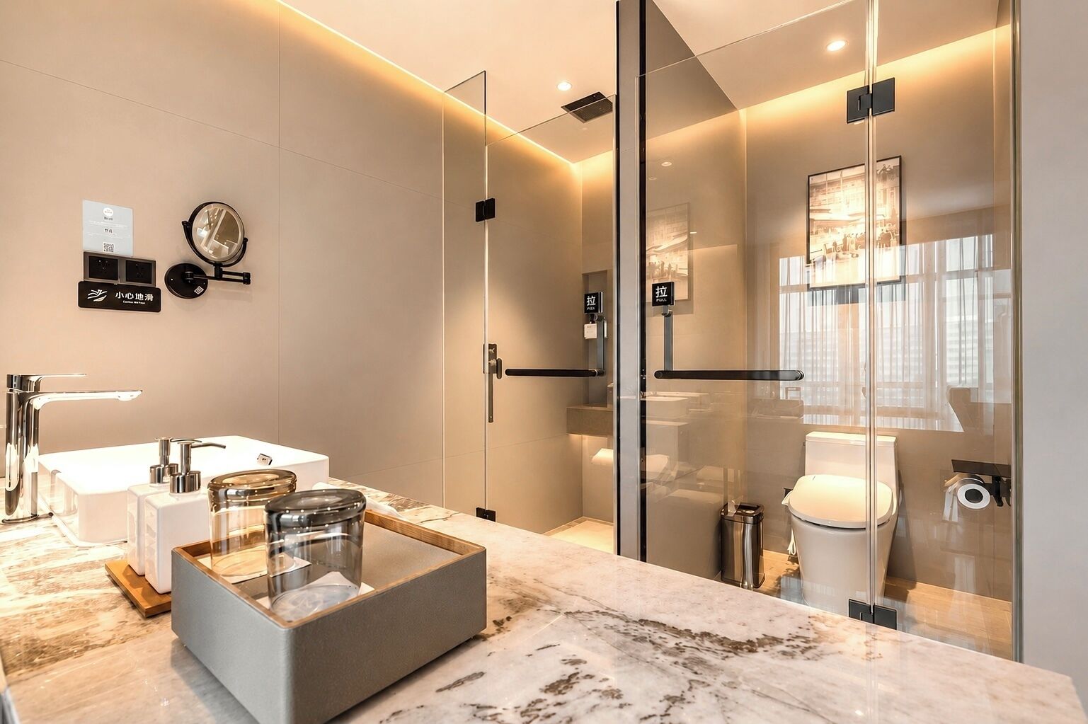 A modern bathroom with a glass-enclosed shower, a marble countertop, and a visible toilet.