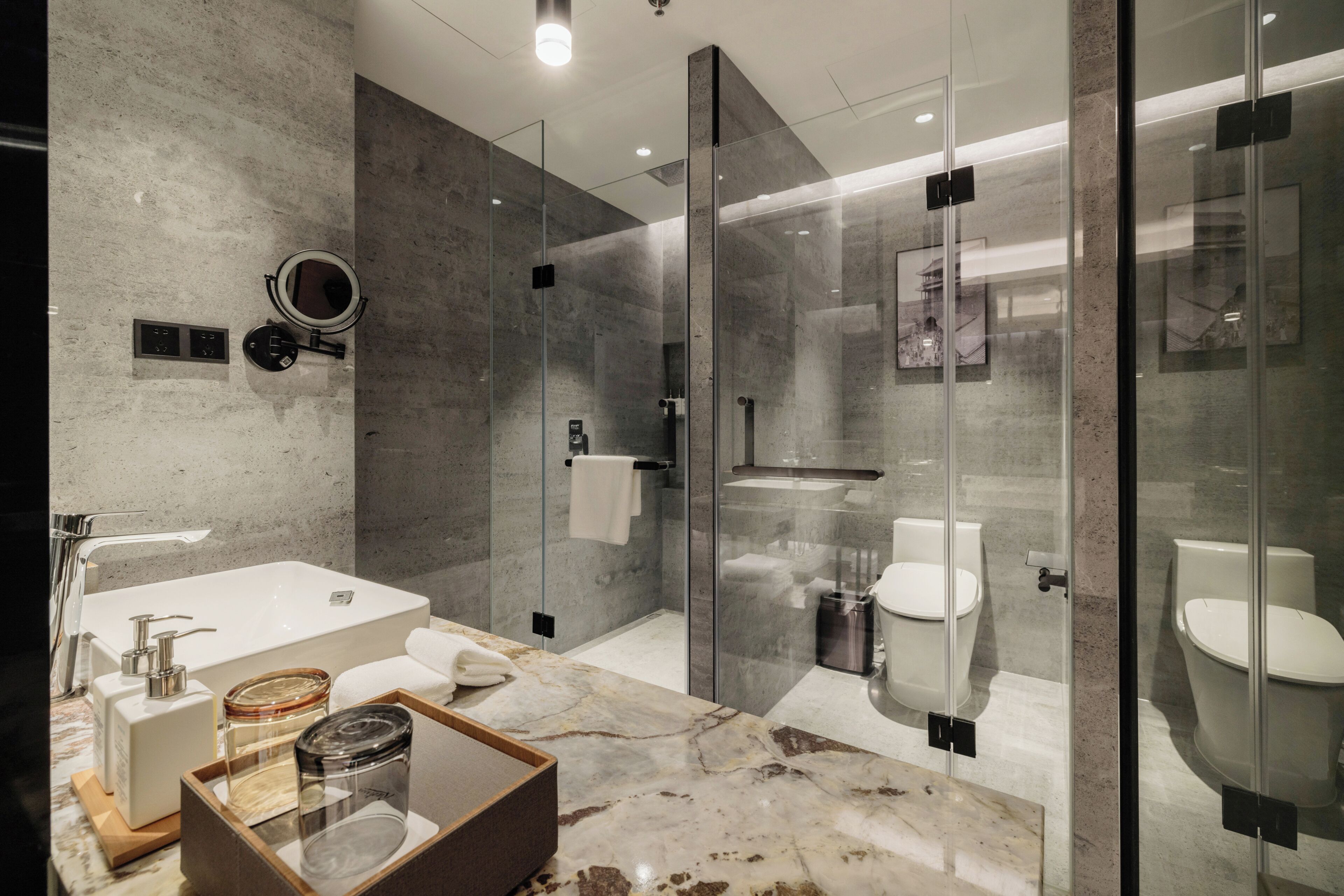A modern bathroom with a glass-enclosed shower, a standalone bathtub, and a toilet.