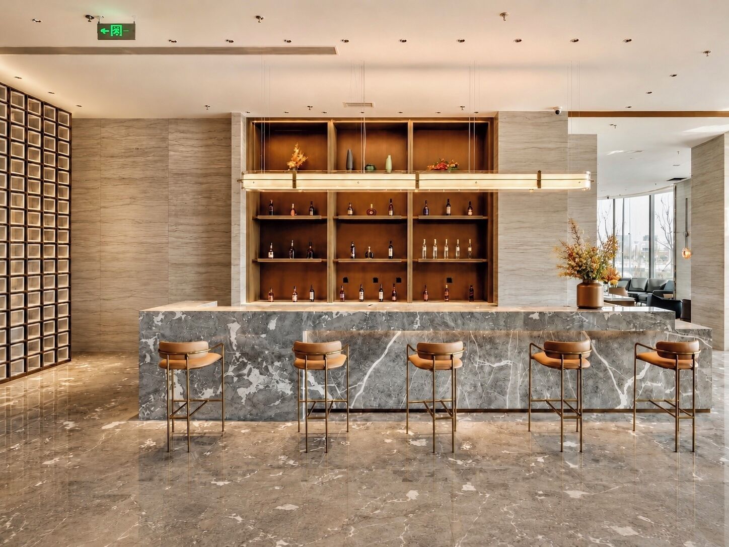 Una zona de bar con mostradores de mármol, taburetes de madera y estantes llenos de botellas.