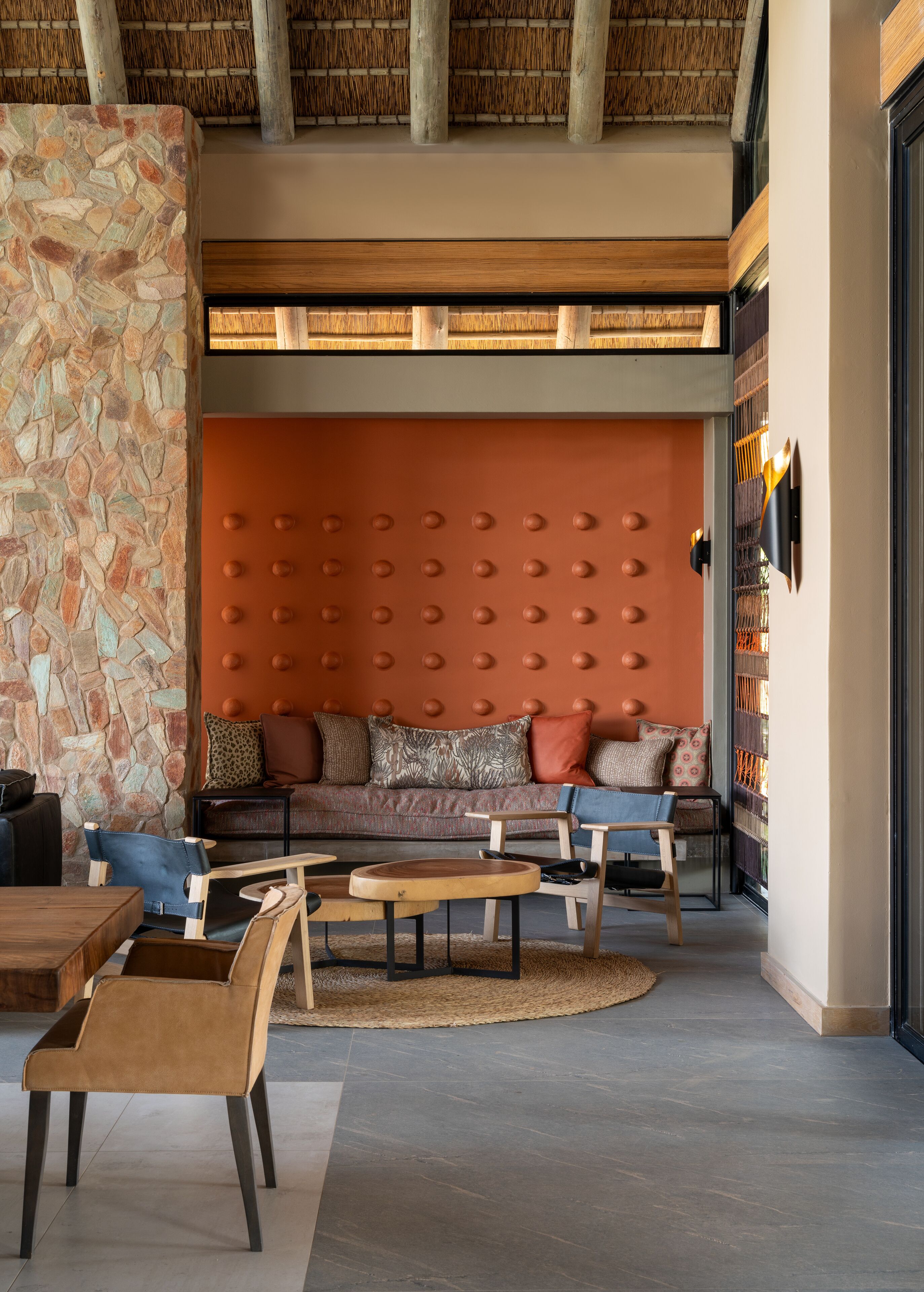 A cozy living area with a stone wall, a cushioned seating area, and a wooden coffee table.