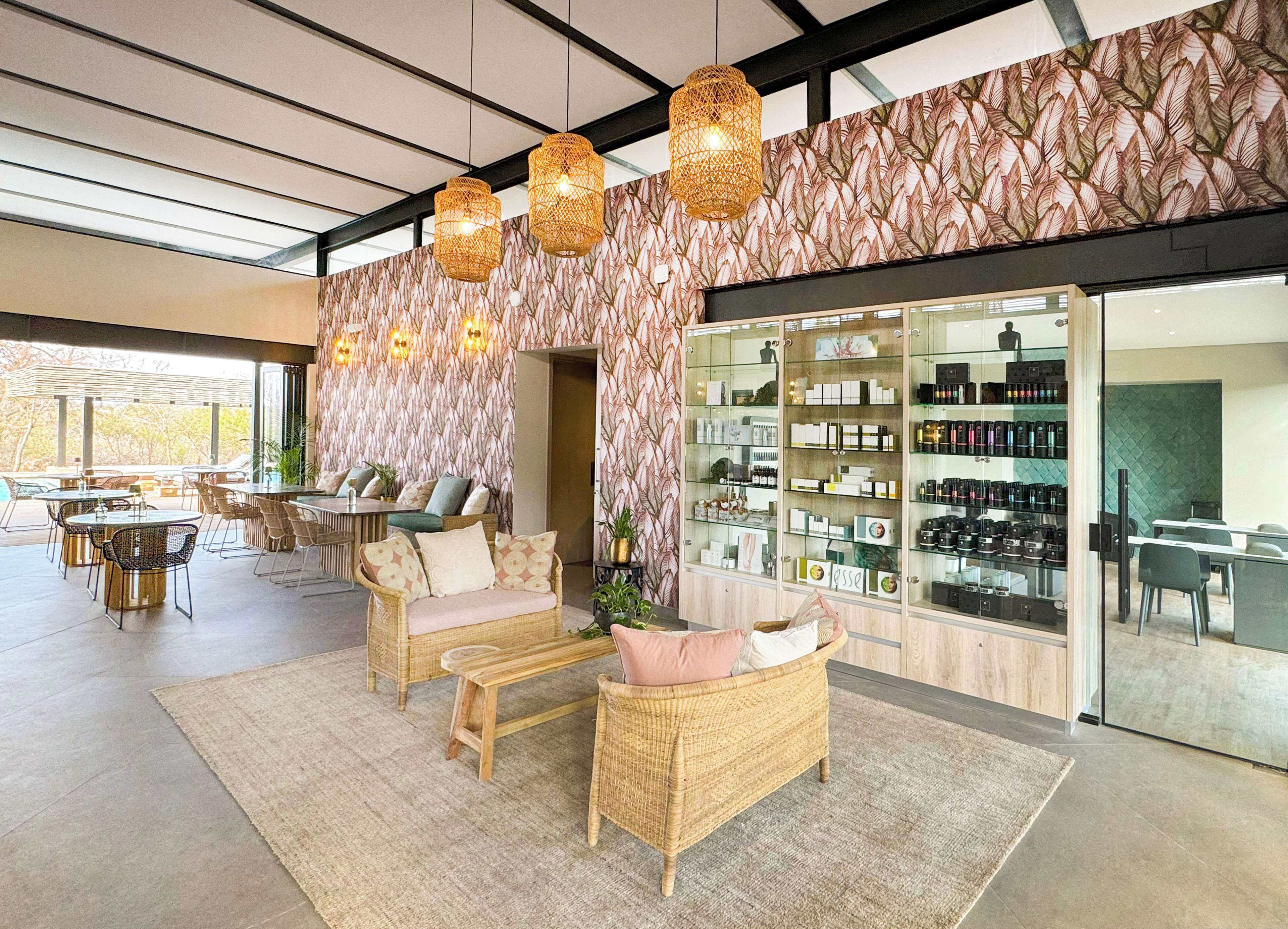 A modern interior with wicker furniture, a glass display case, and a patterned wall.