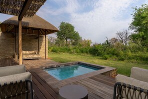 A wooden deck with a hot tub, a covered seating area, and a view of the surrounding greenery. - Radisson Safari Hotel Hoedspruit, A Verified Net Zero Hotel (Hoedspruit)