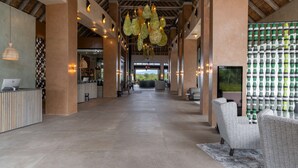 Un hall d’entrée spacieux comprenant un comptoir d’accueil, un espace salon et une grande fenêtre donnant sur l’extérieur.