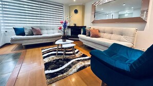 A modern living room with two sofas, a coffee table, and a rug. - Spacios Grand Park 93 (Bogotá)